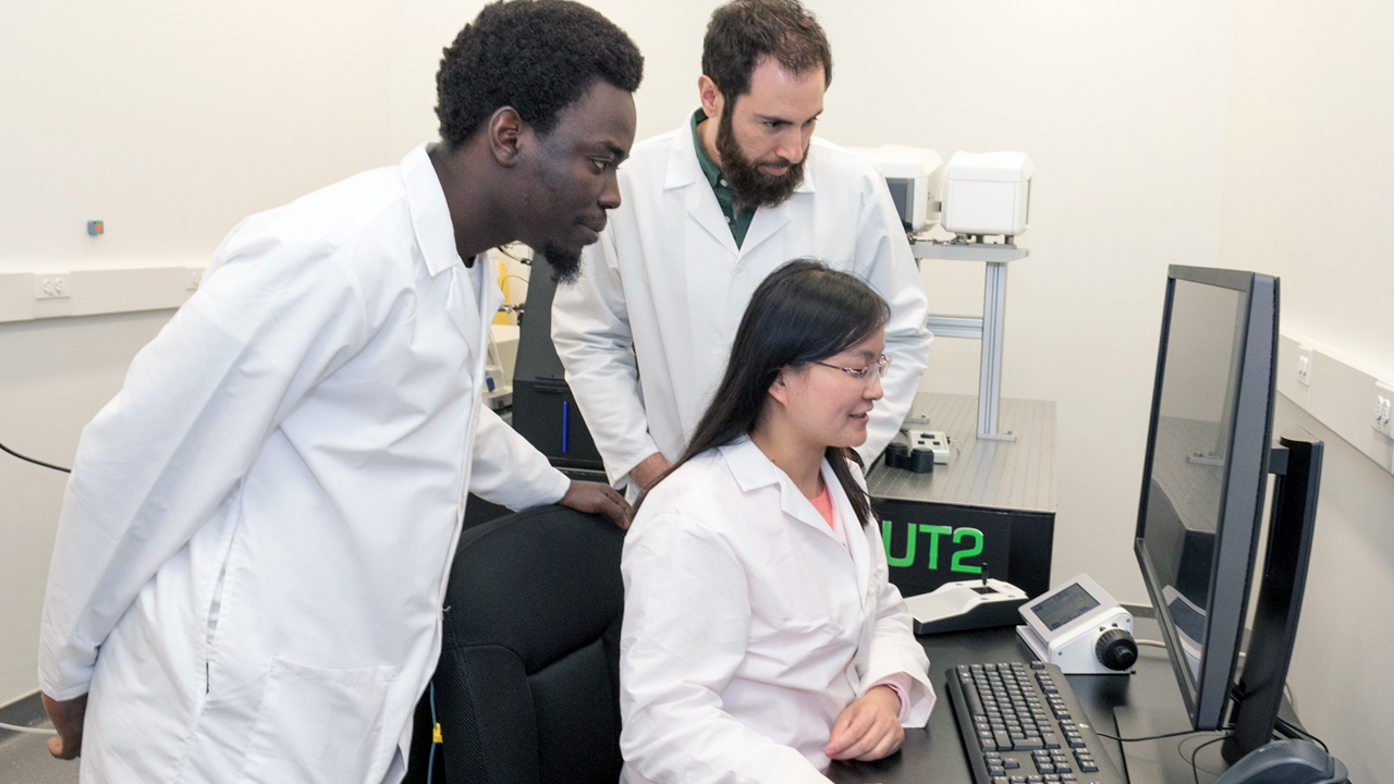 diverse group of neuroscience researchers looking at a computer screen