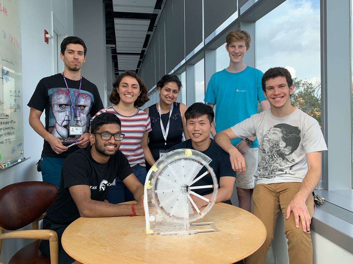 students post with an evaporation wheel inside the ASRC