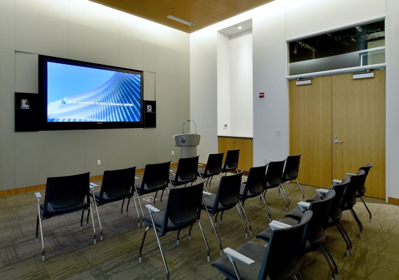 the seminar room pictured from the entryway showing three rows of seats facing a flatscreen display on the wall
