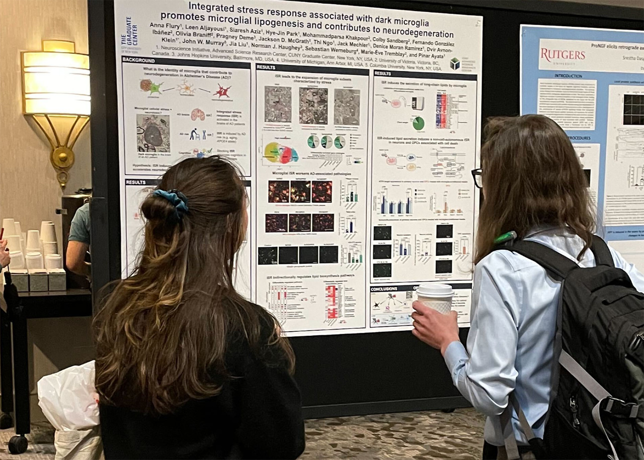 Two students viewing a research poster at a conference