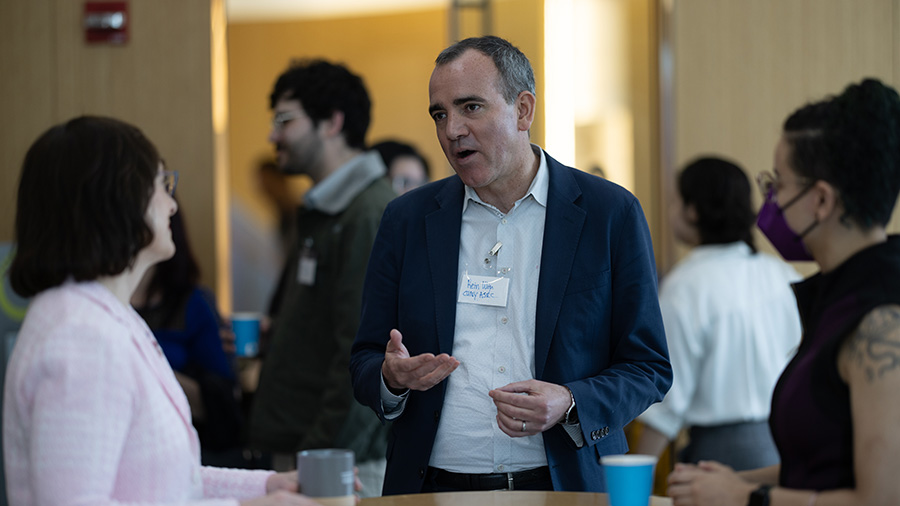 Rein Ulijin in conversation with two women at a networking event at the ASRC.