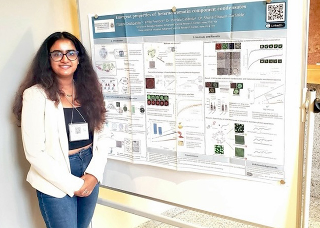 Student standing in front of her research poster at a conference