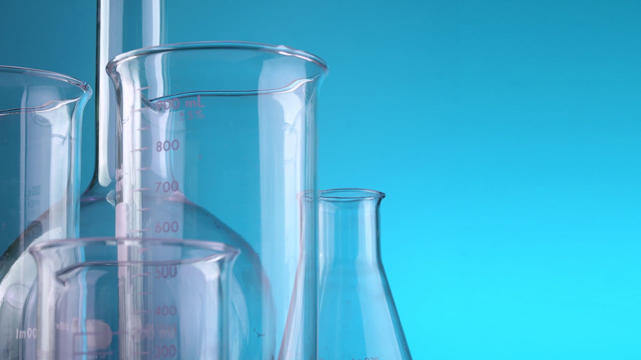 glass beakers and flasks against a blue background